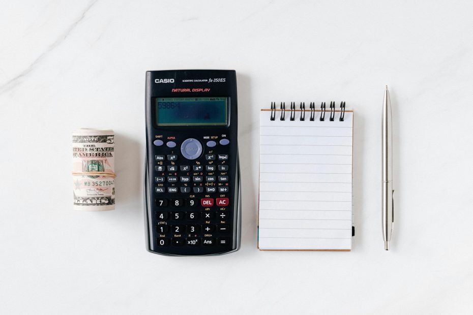Money roll, calculater, notebook and pen shows symbol of financial rules